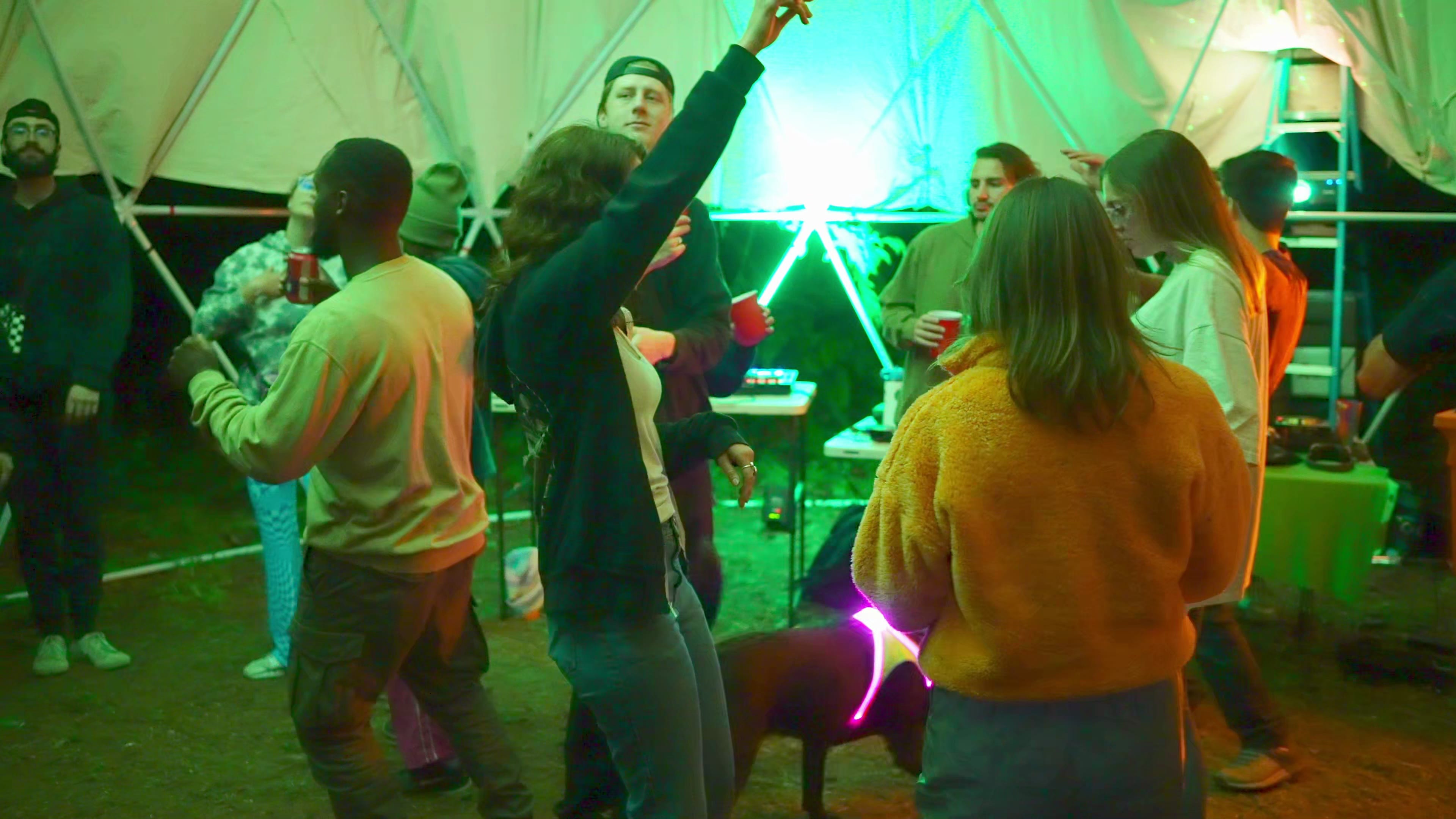 Neon-lit tent dance party at night