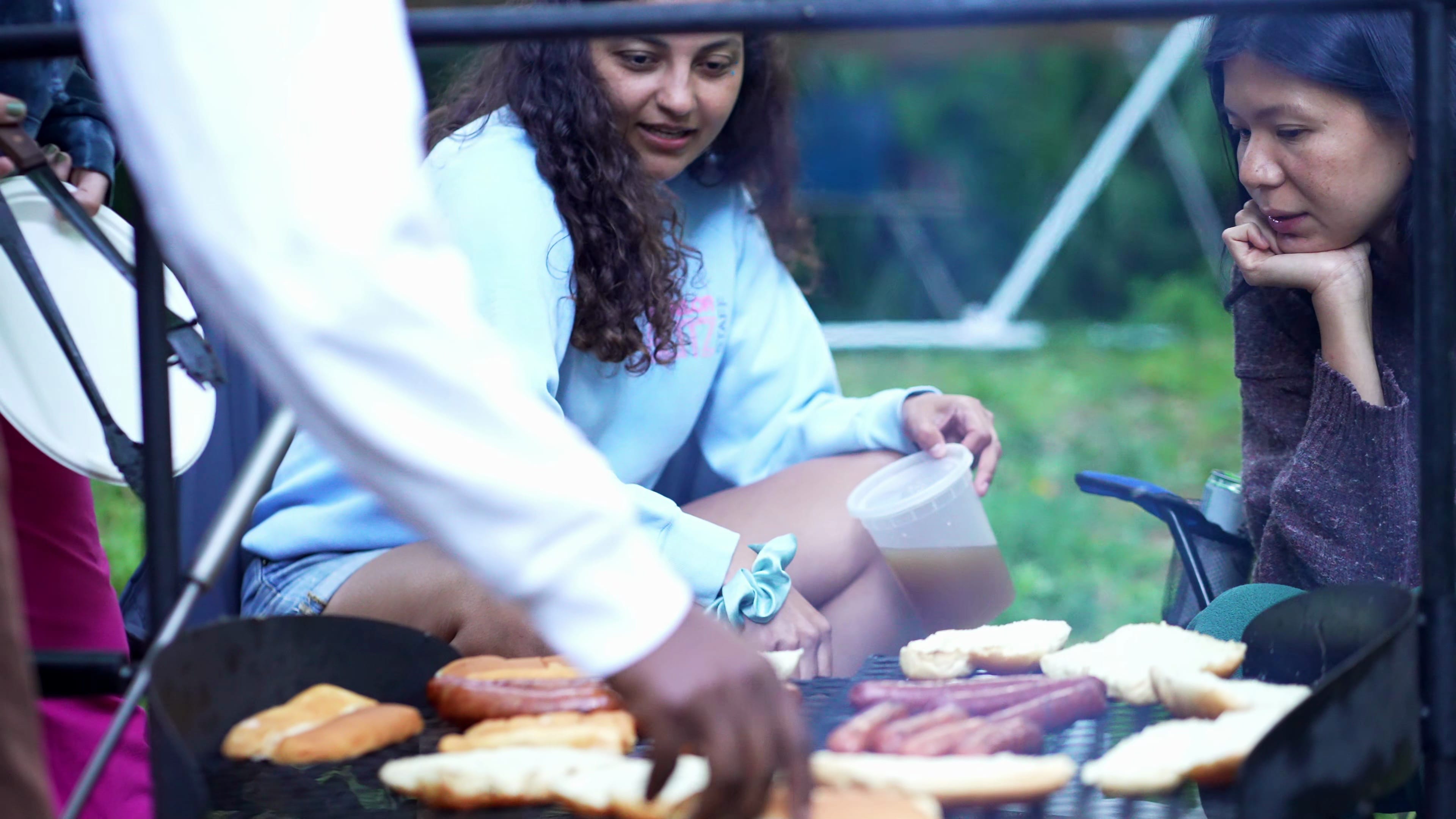 Friends cooking together on a grill at the festival