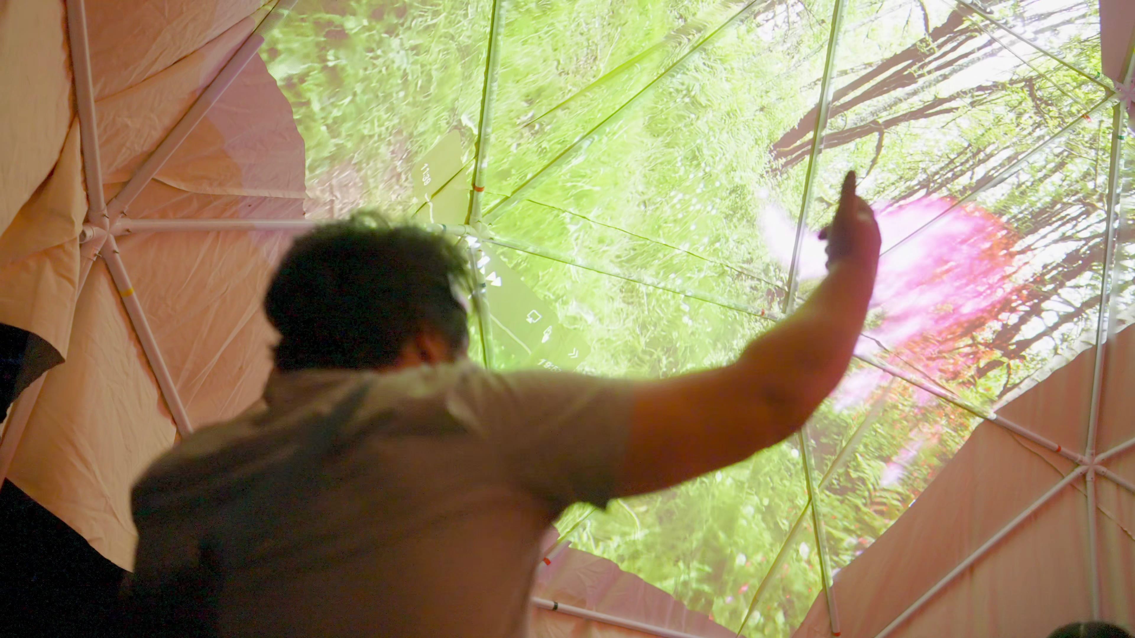 Guy with LED headphones looking at camera in pink neon light at night